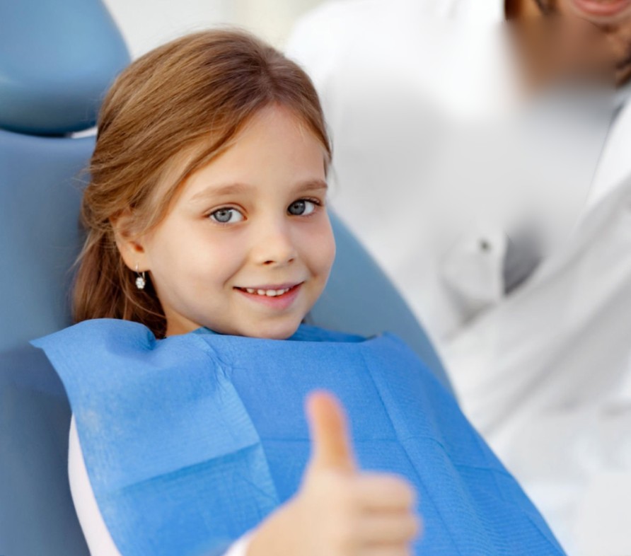 Vajzë e qeshur në karrigen e dentistit gjatë vizitës